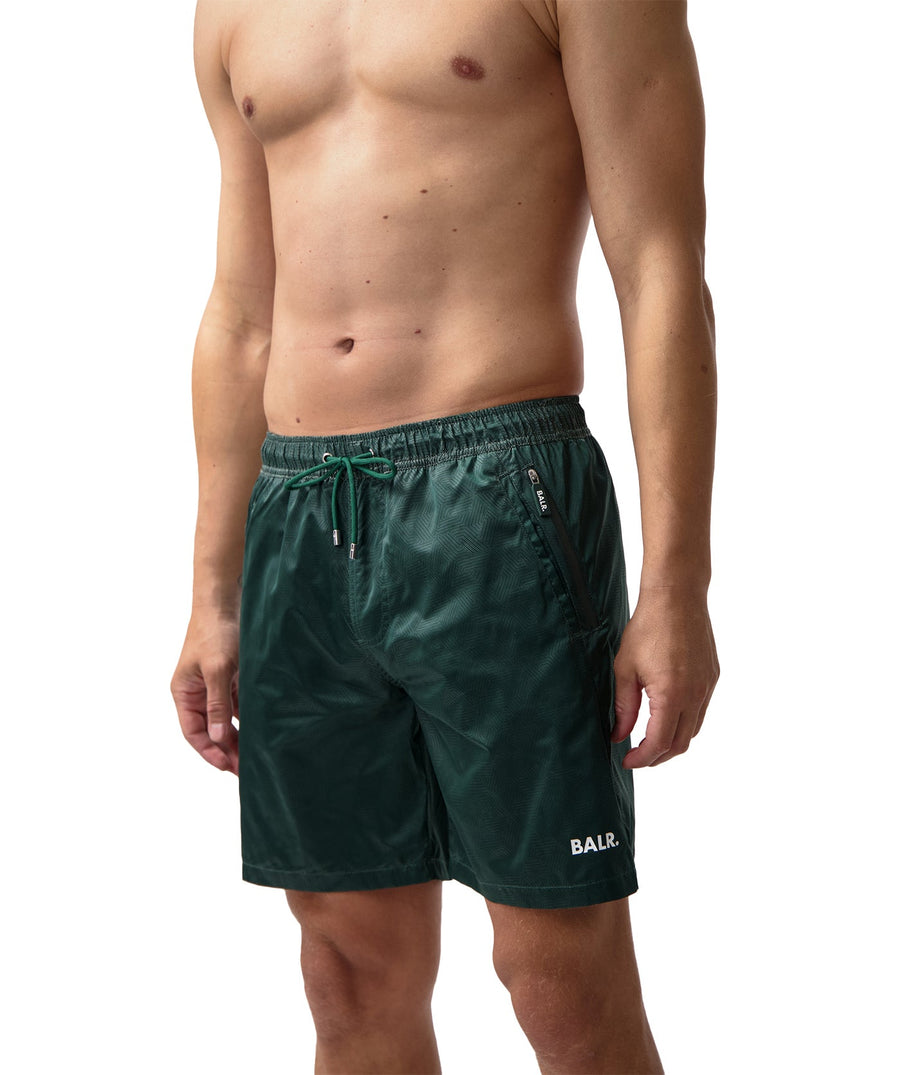 BALR Monogram Swim Shorts B1451.1034 – premium swim shorts featuring an all-over BALR monogram print, an elasticated waistband with a drawcord, and two zippered pockets. Made from lightweight, quick-drying fabric for ultimate comfort and style by the water.