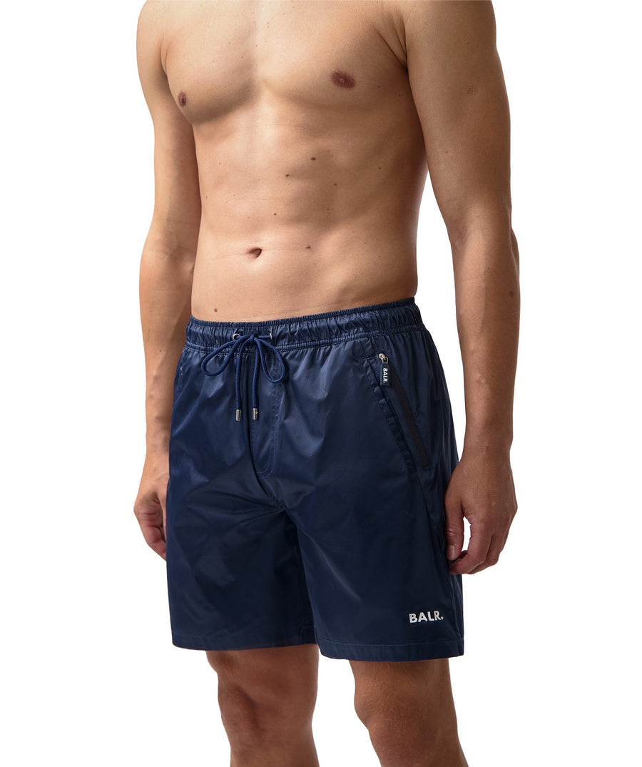 BALR Monogram Swim Shorts B1451.1034 – premium swim shorts featuring an all-over BALR monogram print, an elasticated waistband with a drawcord, and two zippered pockets. Made from lightweight, quick-drying fabric for ultimate comfort and style by the water.