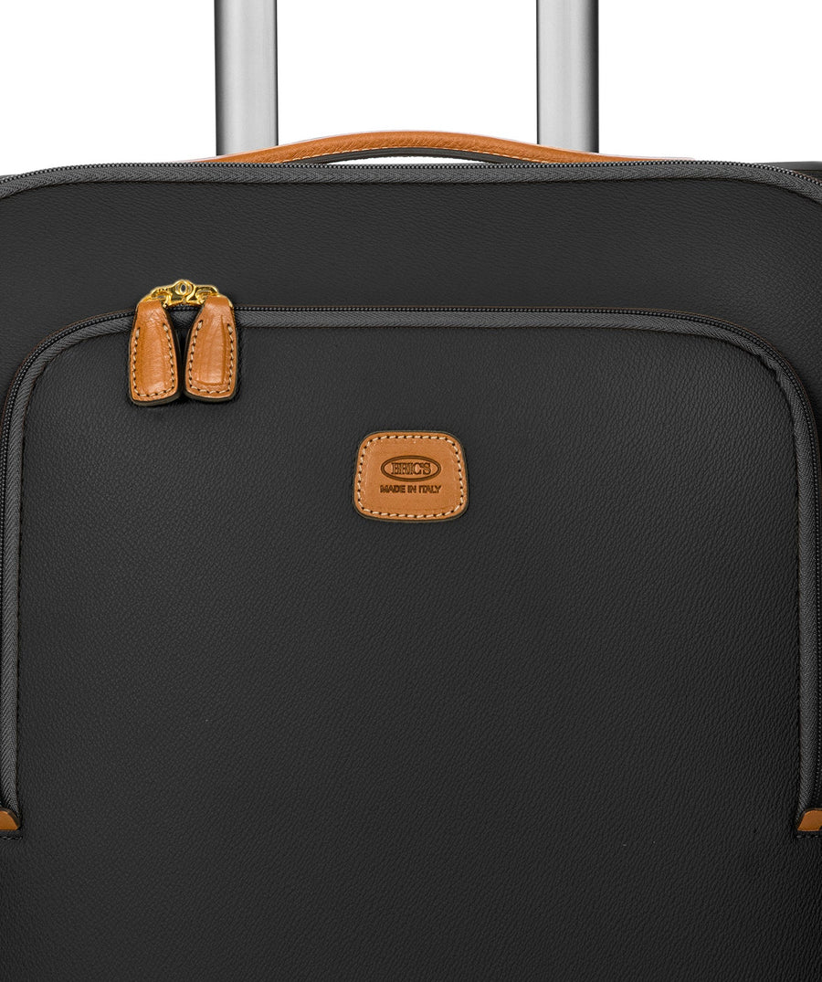 Bric's black 32" Firenze carry-on spinner suitcase with brown leather accents, front zip pocket, gold-tone zippers, telescopic handle, and 360° spinner wheels, style code BBJ15290.001